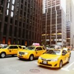 Street scene with yellow taxis in New York City, iconic urban traffic captured in daylight.